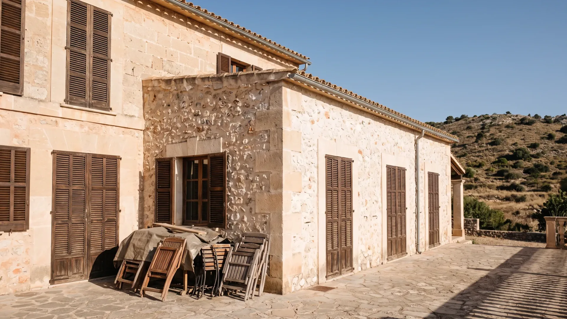 Mallorcan villa shut up for the winter with closed shutters and terrace furniture stacked