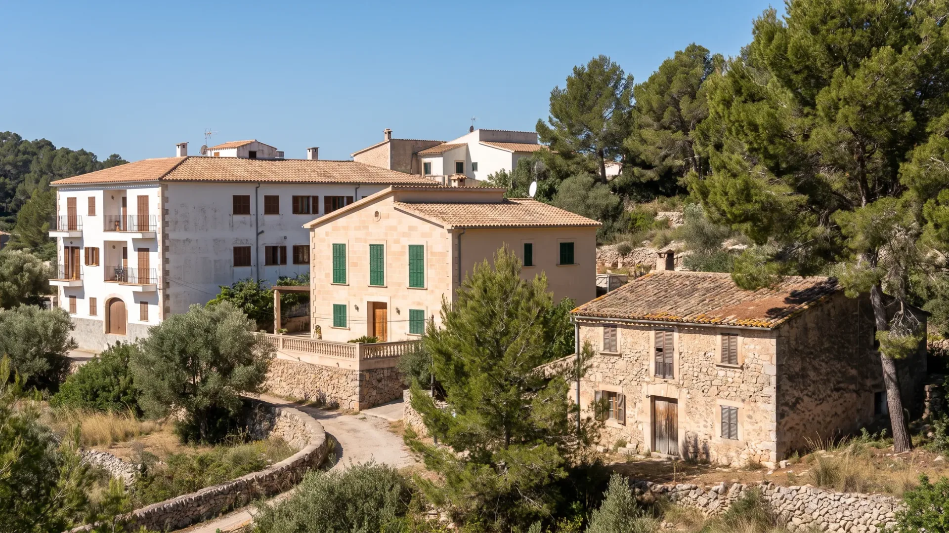 Mallorcan villa, apartment block and older stone house seen together from a pine hillside