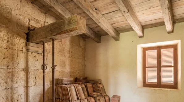 Mallorcan ceiling of heavy timber beams with one bearing opened for repair and props under it