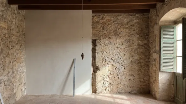 New flush plasterwork stopping short of an old stone wall in a Mallorcan room at a recessed break