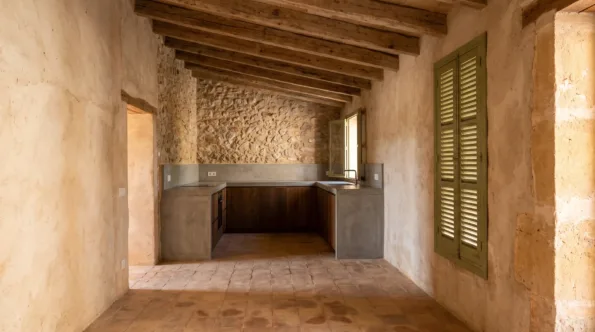Rough plastered Mallorcan room with exposed beams and a flush kitchen run scribed to the stone